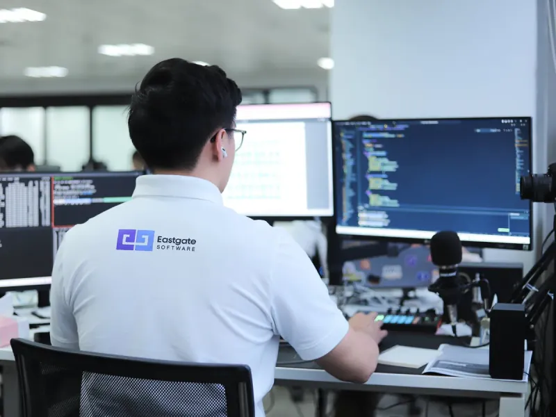 Eastgate engineer working on code with multi-monitor setup